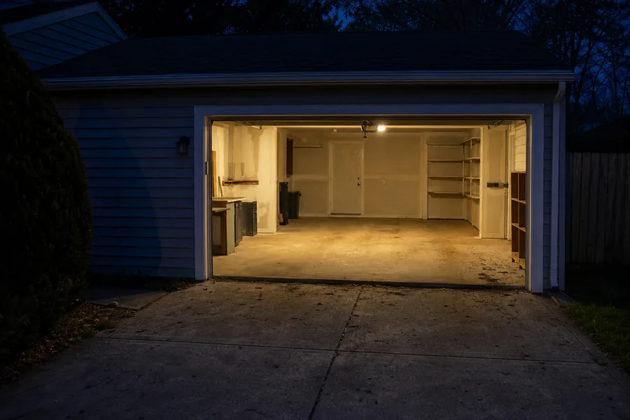 Three-car garage door on a newer house at dusk